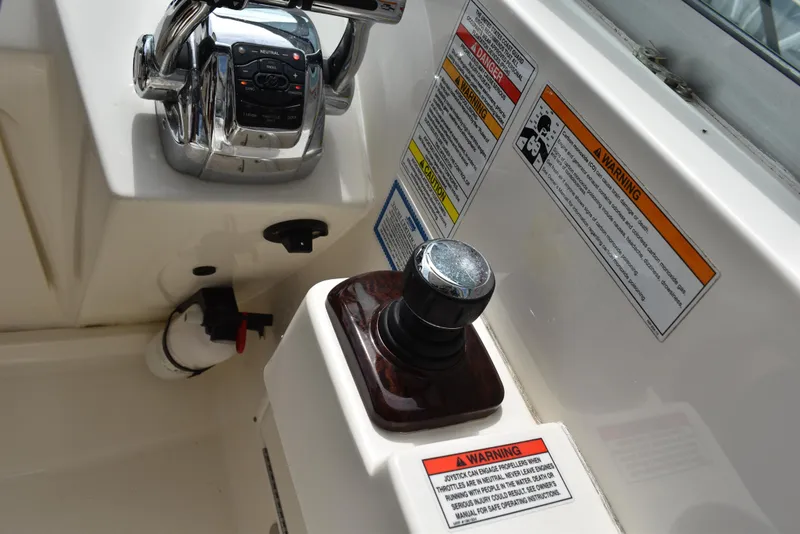 Slide: The Image of Control panel of 2011 Sea Ray 310 Sundancer with joystick and warning labels. - 25