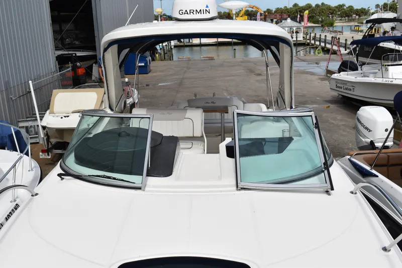 Slide: The Image of 2011 Sea Ray 310 Sundancer boat docked, featuring open cockpit and Garmin equipment. - 31