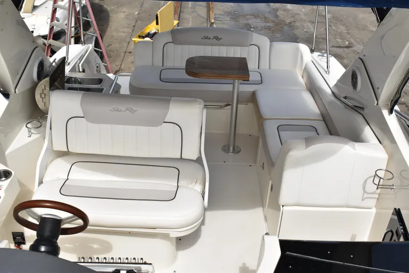 Slide: The Image of 2011 Sea Ray 310 Sundancer boat interior with white seating and wooden table. - 33
