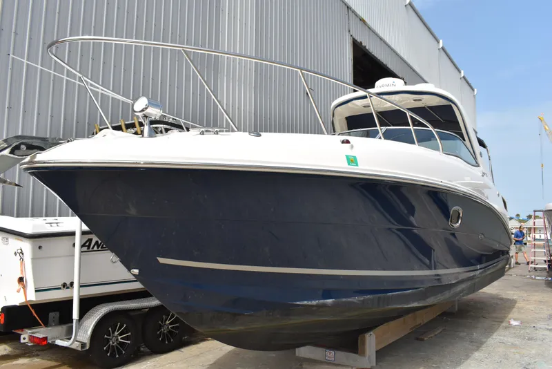 Slide: The Image of 2011 Sea Ray 310 Sundancer boat docked near a warehouse. - 4
