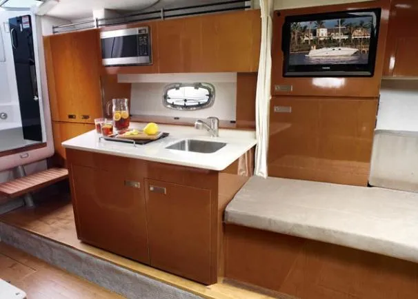 Slide: The Image of Interior of 2011 Sea Ray 310 Sundancer yacht with kitchenette and seating area. - 42