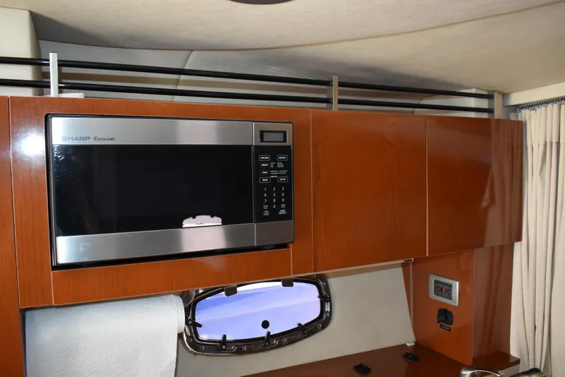 Slide: The Image of Interior of 2011 Sea Ray 310 Sundancer with microwave and wooden cabinetry. - 43