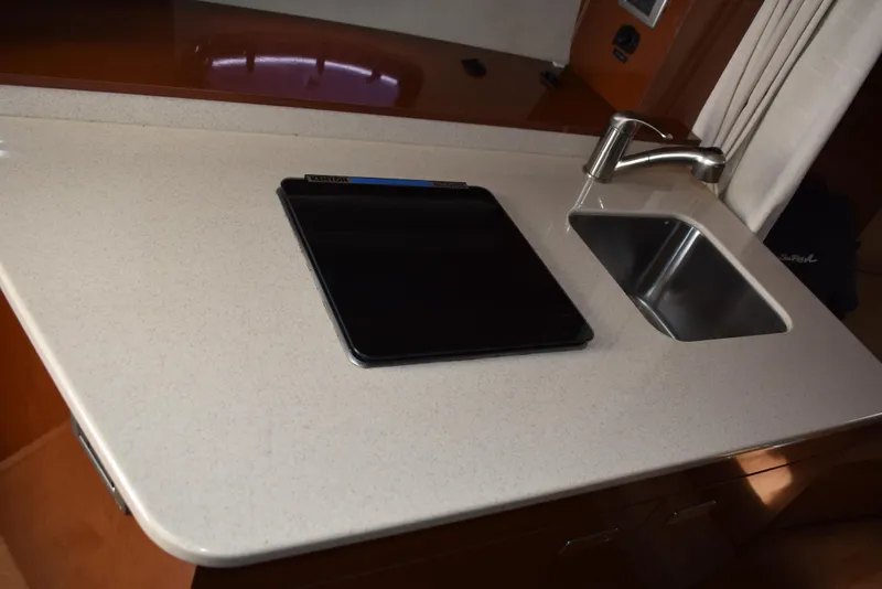 Slide: The Image of 2011 Sea Ray 310 Sundancer galley with sink and stove. - 44