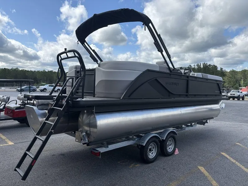 Slide: The Image of 2025 Godfrey SWEETWATER 2286 SB pontoon boat on trailer, under cloudy sky. - 3