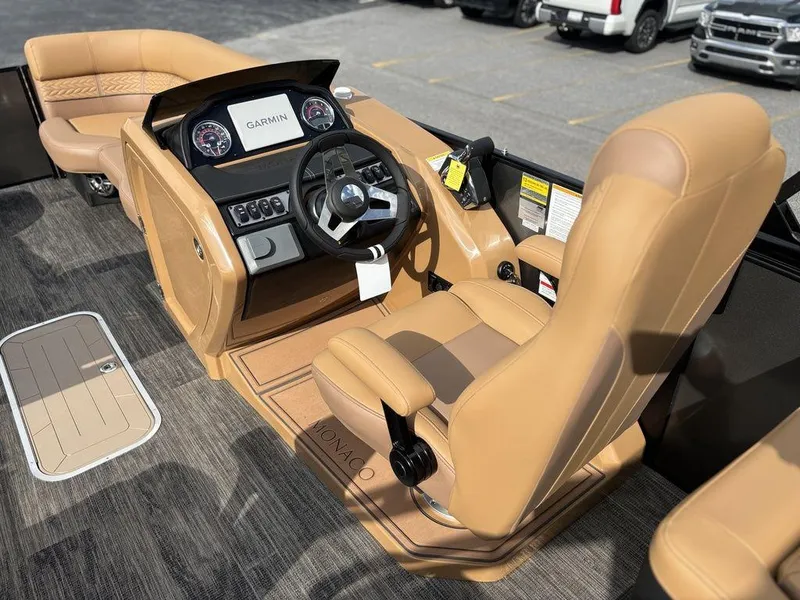 Slide: The Image of 2025 Godfrey Monaco 235 SB boat interior with tan seating and Garmin dashboard. - 12