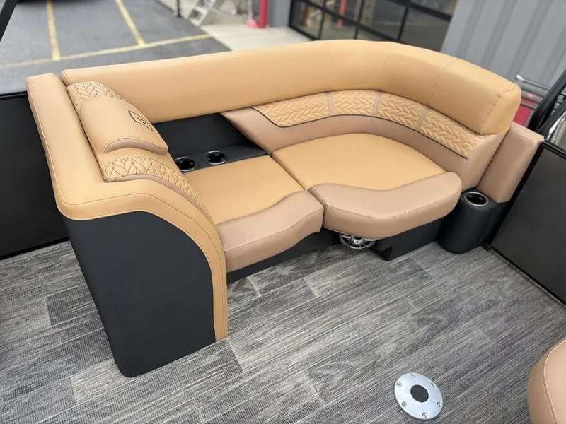 Slide: The Image of Luxurious seating on 2025 Godfrey Monaco 235 SB boat, featuring tan upholstery and cup holders. - 17