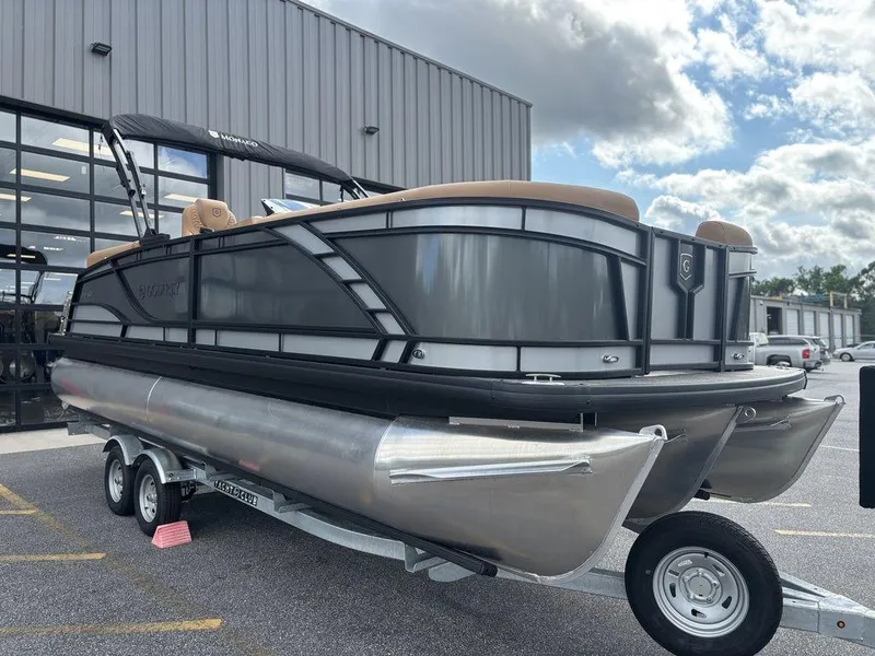 Slide: The Image of 2025 Godfrey Monaco 235 SB pontoon boat on trailer, parked outside a building. - 7