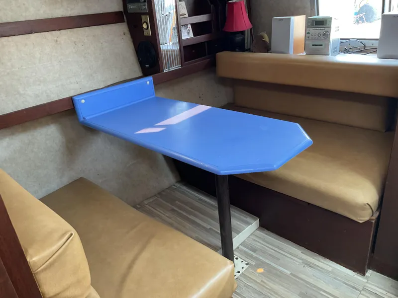 Slide: The Image of Interior of 1985 Cruisers Yachts 291 Sea Devil with blue table and tan seating. - 13