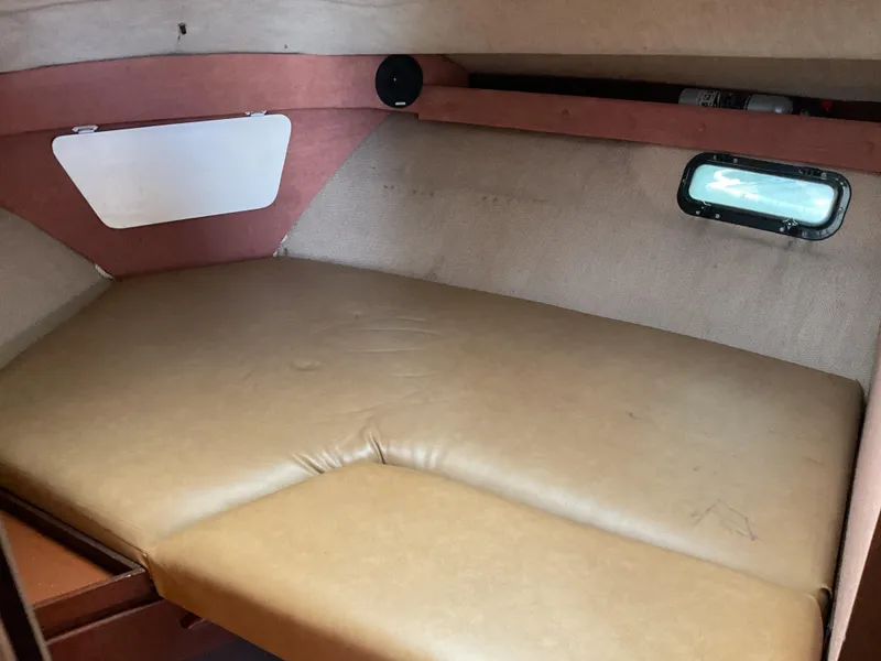 Slide: The Image of 1985 Cruisers Yachts 291 Sea Devil cabin interior with cushioned berth and small window. - 18