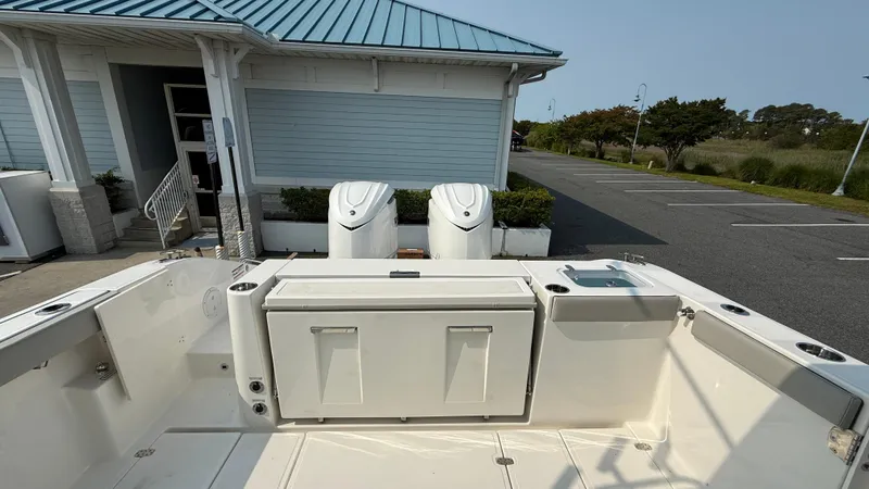 Slide: The Image of 2025 Pursuit S 328 Sport boat with dual engines, docked near a building. - 11