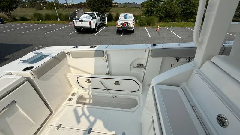 Slide: The Image of 2025 Pursuit S 328 Sport boat interior with storage compartments in a parking lot. - 23