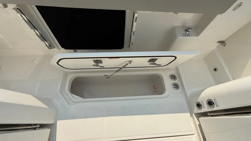 Slide: The Image of 2025 Pursuit S 328 Sport boat interior with open storage compartment. - 28