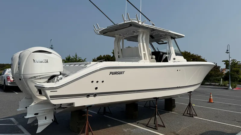 Slide: The Image of 2025 Pursuit S 328 Sport boat on display in a parking lot. - 3