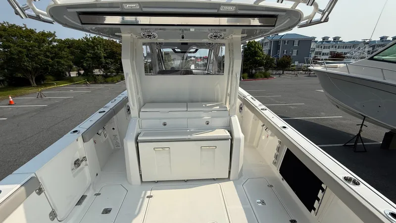 Slide: The Image of 2025 Pursuit S 328 Sport boat interior with seating and storage, docked in a marina. - 30