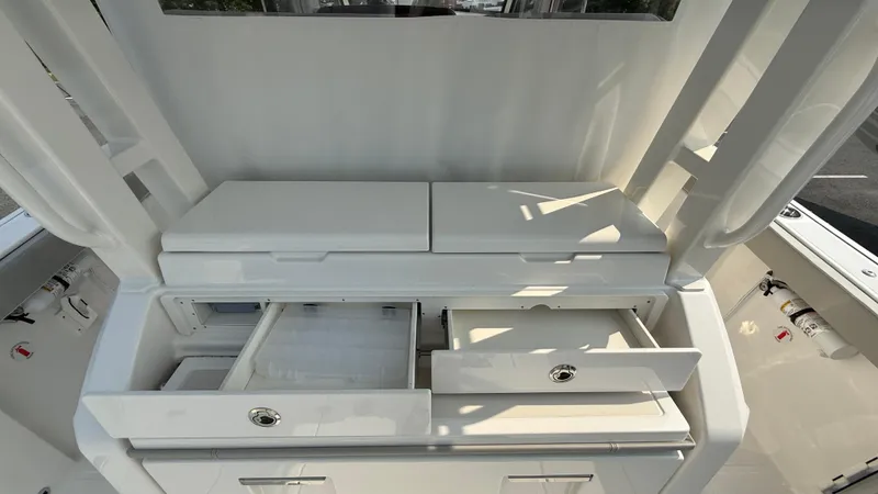Slide: The Image of 2025 Pursuit S 328 Sport boat interior with open storage compartments and drawers. - 34