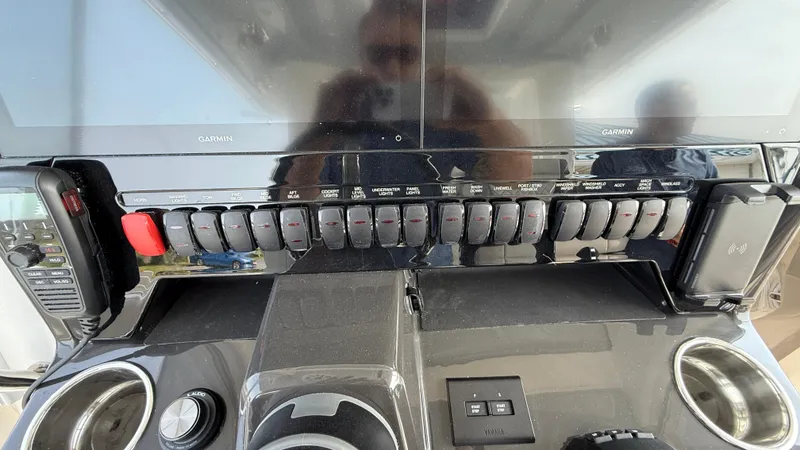 Slide: The Image of Control panel of 2025 Pursuit S 328 Sport boat with switches and cup holders. - 42