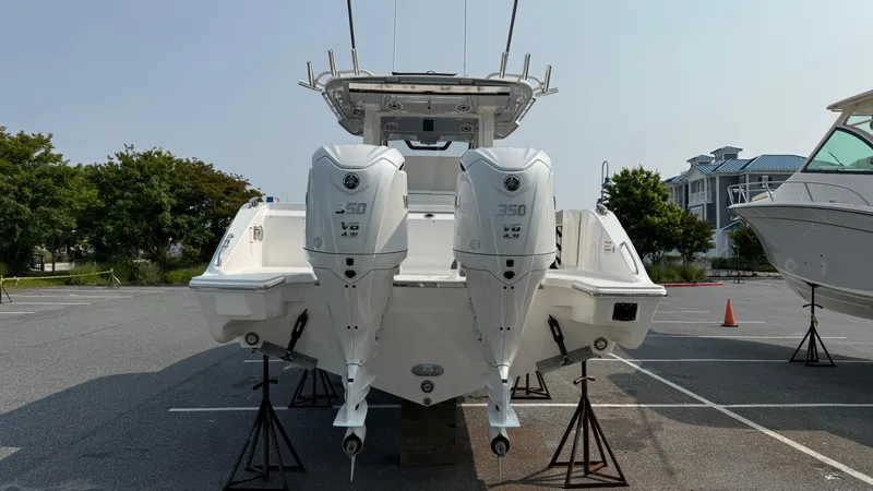 Slide: The Image of 2025 Pursuit S 328 Sport boat with dual engines on display in a parking lot. - 5