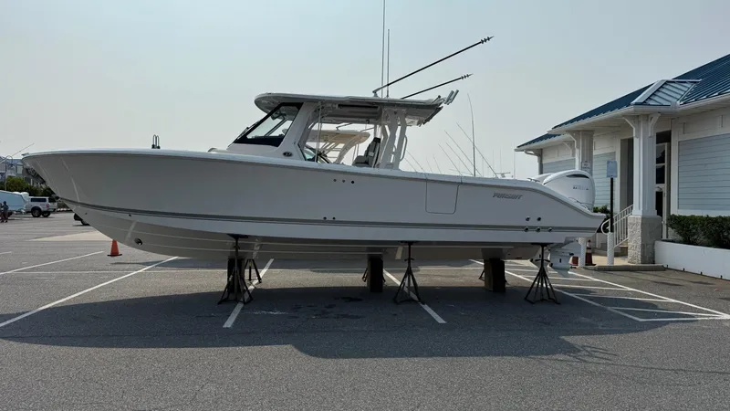 Slide: The Image of 2025 Pursuit S 328 Sport boat on stands in a parking lot. - 6