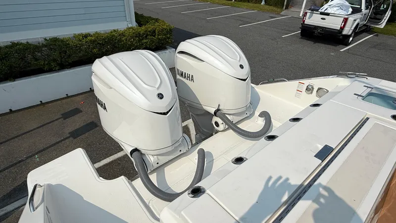 Slide: The Image of 2025 Pursuit S 328 Sport boat with dual Yamaha outboard engines in a parking lot. - 9