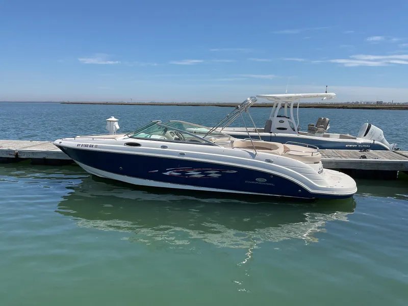 The Image of 2006 Chaparral 256 SSi boat docked on calm water under clear blue sky. - 0
