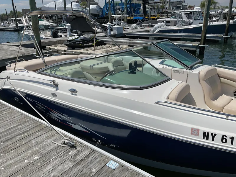 Slide: The Image of 2006 Chaparral 256 SSi boat docked at a marina, featuring sleek design and comfortable seating. - 2