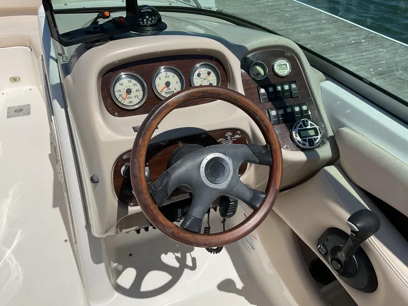 Slide: The Image of 2006 Chaparral 256 SSi boat dashboard with wood-trimmed steering wheel and gauges. - 5