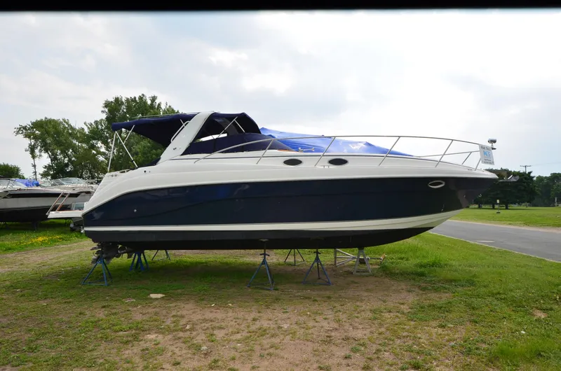 Slide: The Image of 2006 Rinker 342 Fiesta Vee boat on stands, parked on grassy area. - 13