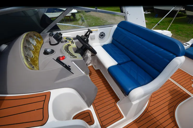 Slide: The Image of 2006 Rinker 342 Fiesta Vee boat cockpit with blue seating and wood-style flooring. - 19