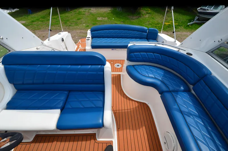 Slide: The Image of 2006 Rinker 342 Fiesta Vee boat interior with blue seating and wooden deck. - 20