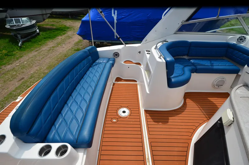 Slide: The Image of 2006 Rinker 342 Fiesta Vee boat interior with blue seating and teak flooring. - 23