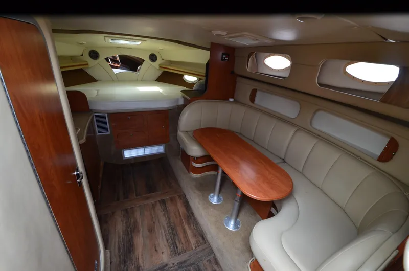 Slide: The Image of 2006 Rinker 342 Fiesta Vee cabin interior with beige seating and wooden table. - 25