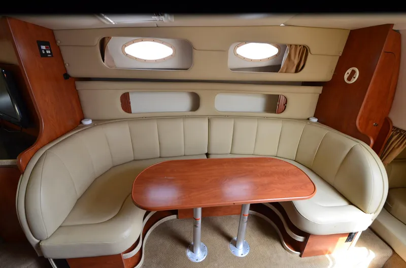 Slide: The Image of 2006 Rinker 342 Fiesta Vee cabin with beige seating and wooden table. - 28