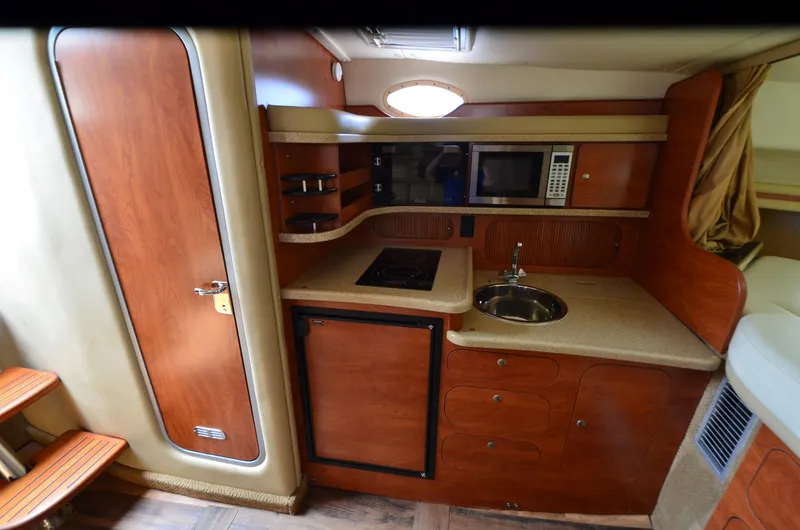 Slide: The Image of 2006 Rinker 342 Fiesta Vee boat interior kitchen with wood cabinetry and modern appliances. - 29