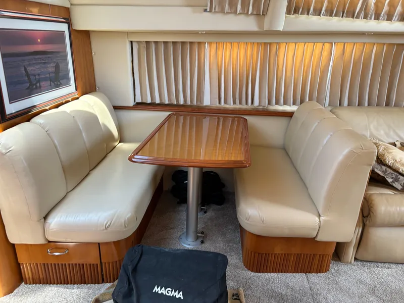 Slide: The Image of Interior of 2005 Carver 44 CPMY yacht with beige seating and wooden table. - 20