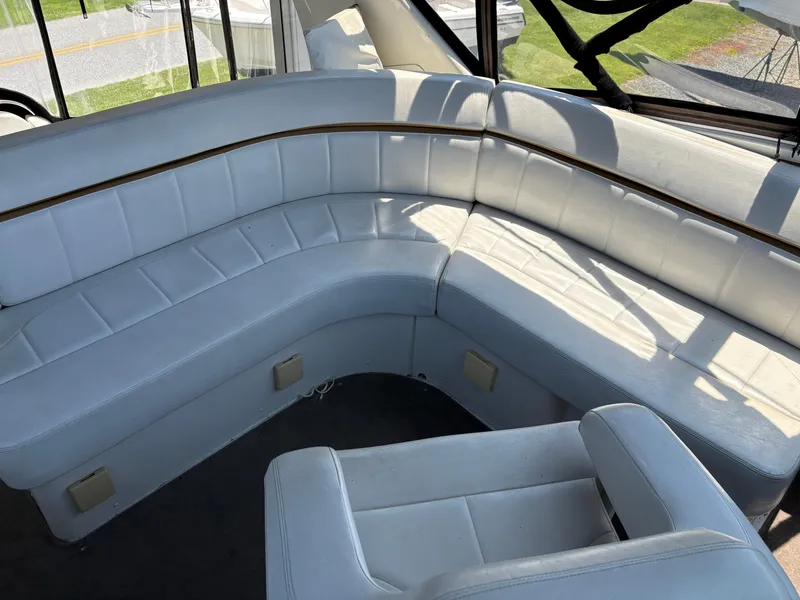 Slide: The Image of 2005 Carver 44 CPMY yacht interior with white leather seating and natural light. - 9