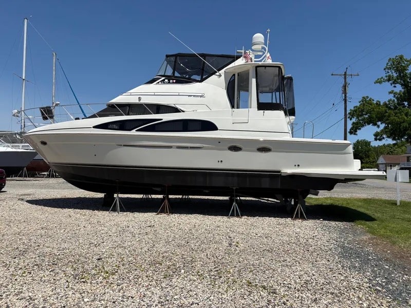 The Image of 2005 Carver 44 CPMY yacht on stands, displayed outdoors on gravel. - 0