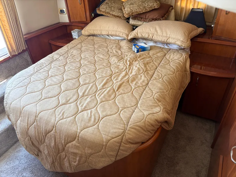Slide: The Image of Cozy bedroom in 2005 Carver 44 CPMY yacht with beige bedding and wooden accents. - 24