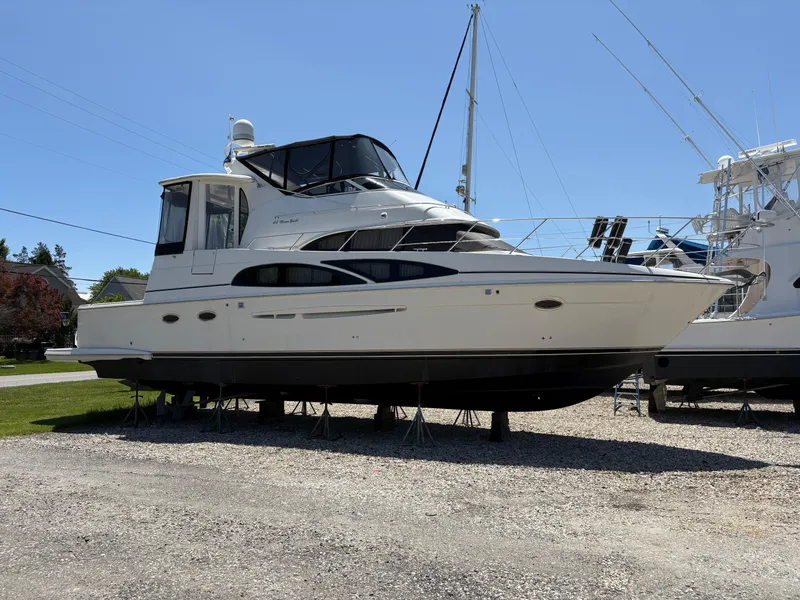 Slide: The Image of 2005 Carver 44 CPMY yacht on dry dock, side view, clear sky background. - 1