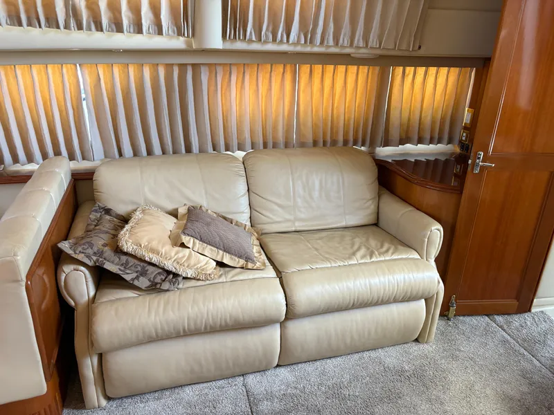 Slide: The Image of Luxurious interior of 2005 Carver 44 CPMY with beige leather sofa and decorative pillows. - 18