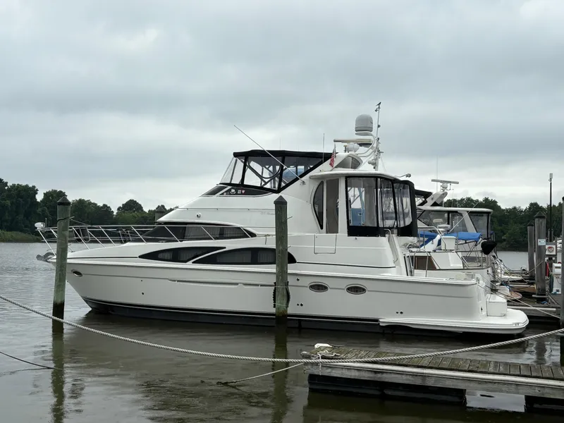 Slide: The Image of 2005 Carver 44 CPMY yacht docked at a marina on a cloudy day. - 33