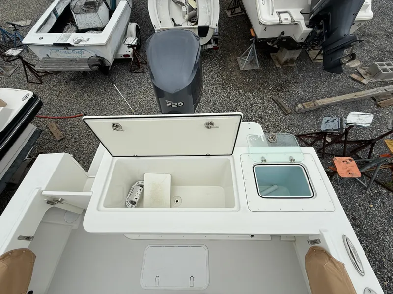 Slide: The Image of 2019 Parker 2320 Sport Cabin boat with open storage compartments and outboard motor. - 16