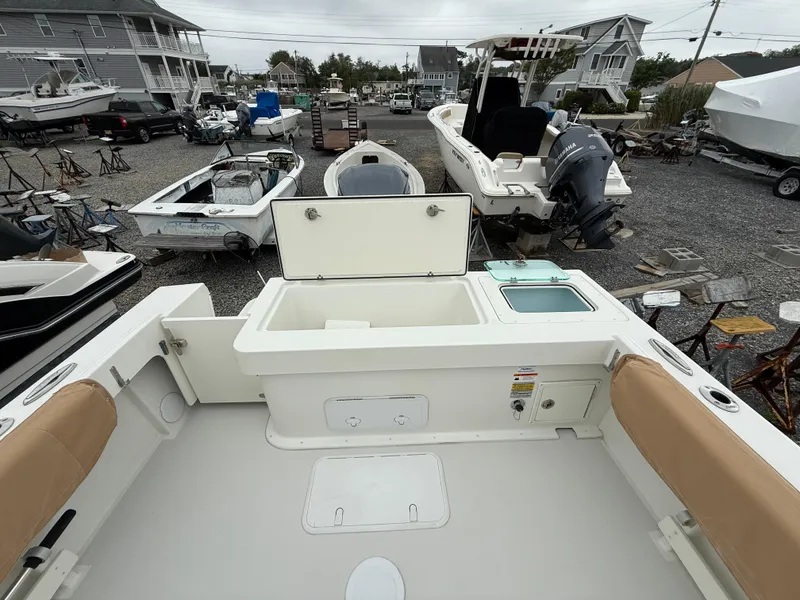Slide: The Image of 2019 Parker 2320 Sport Cabin boat in a marina, surrounded by other vessels. - 17