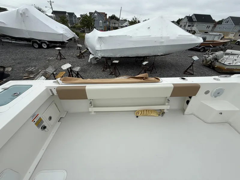 Slide: The Image of 2019 Parker 2320 Sport Cabin boat deck with covered boats in the background. - 19