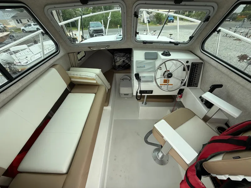 Slide: The Image of 2019 Parker 2320 Sport Cabin interior with steering wheel, seating, and navigation equipment. - 20