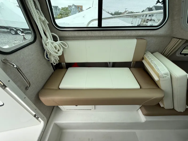 Slide: The Image of Interior of 2019 Parker 2320 Sport Cabin with cushioned seating and window view. - 21