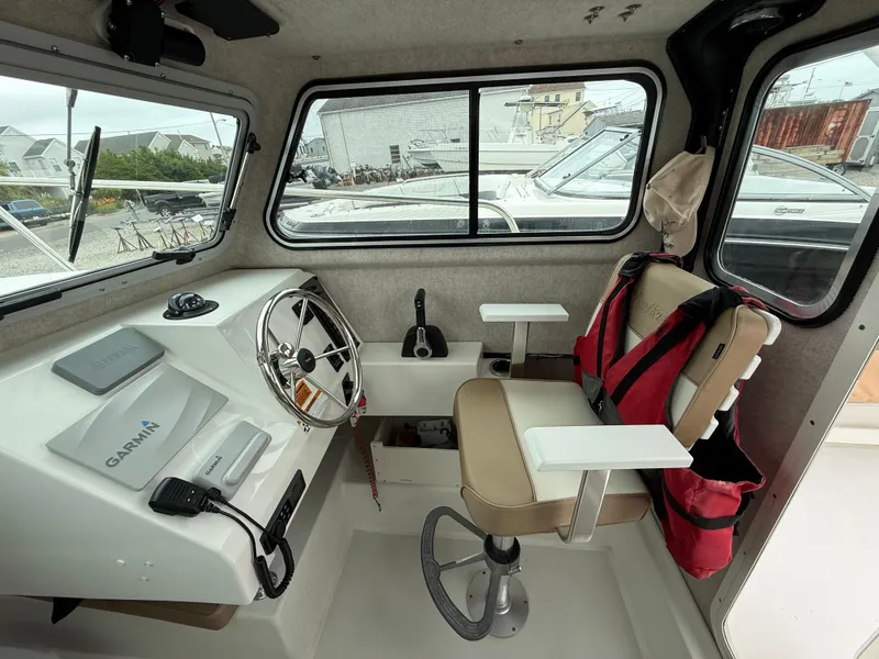 Slide: The Image of Interior of a 2019 Parker 2320 Sport Cabin boat with steering wheel and Garmin equipment. - 23