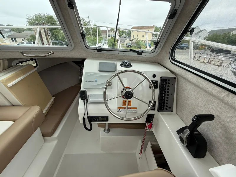 Slide: The Image of 2019 Parker 2320 Sport Cabin interior with steering wheel, Garmin navigation, and control panel. - 24