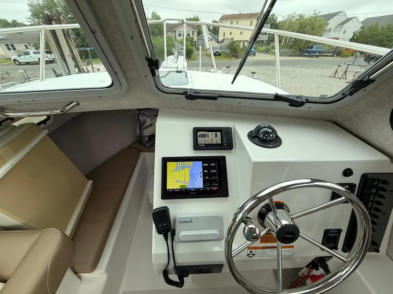 Slide: The Image of 2019 Parker 2320 Sport Cabin boat interior with navigation equipment and steering wheel. - 25