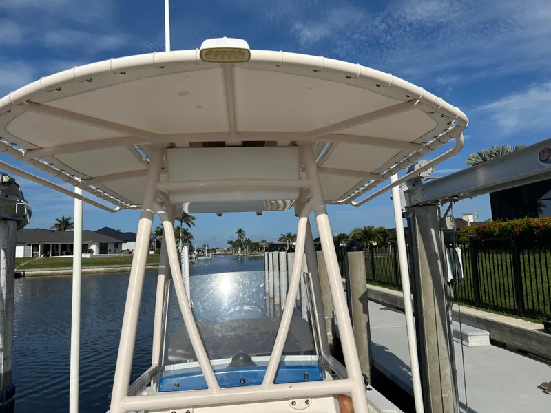 Slide: The Image of 2019 Pathfinder 2200 CC boat docked by a canal under a clear blue sky. - 10