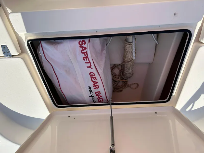 Slide: The Image of Open storage compartment on 2019 Pathfinder 2200 CC boat with safety gear bag and rope. - 15